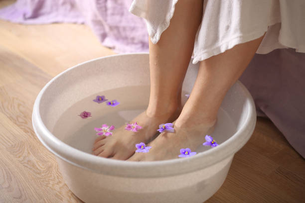 Female feet in spa bowl with flowers